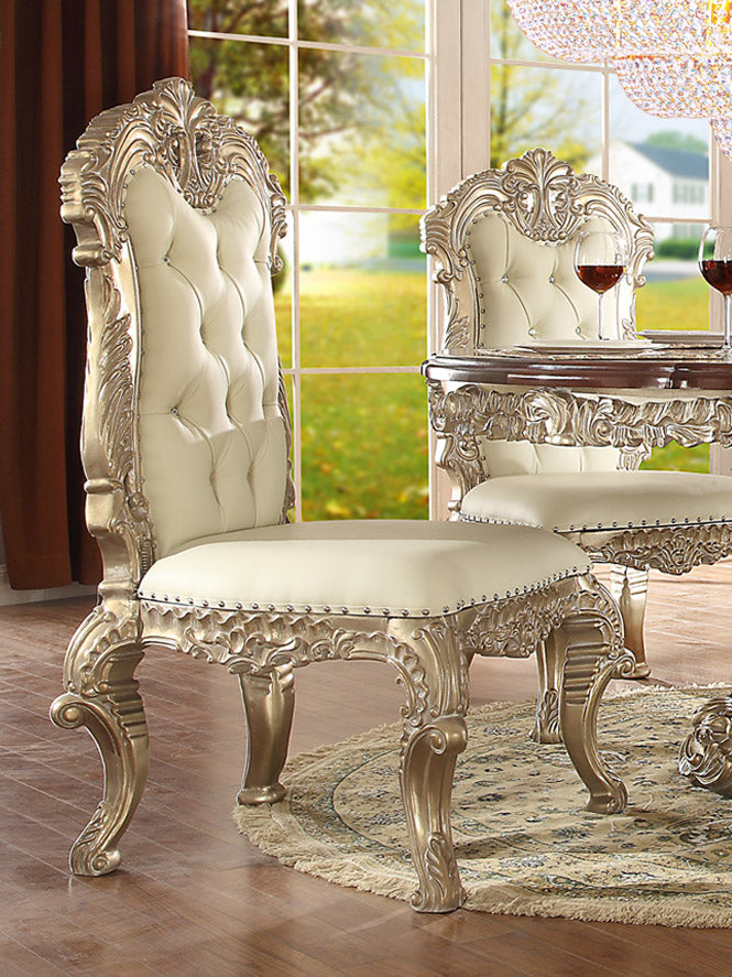 Elegant dining chair with tufted leather upholstery and detailed carvings in metallic silver.