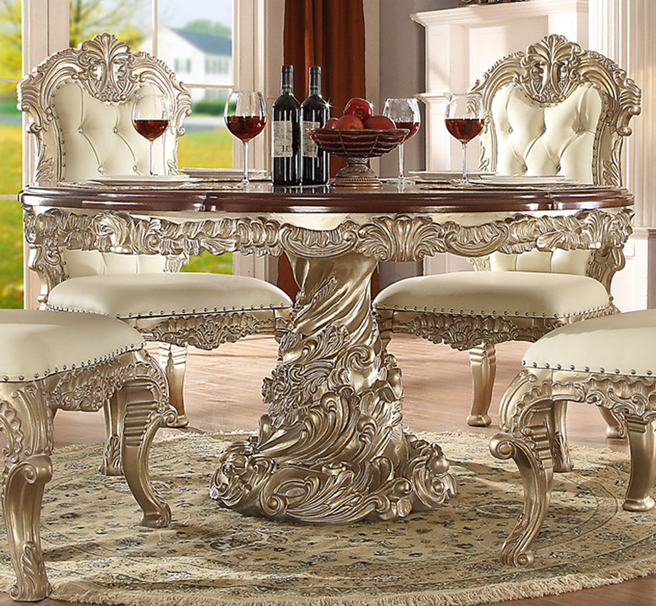 Intricate round dining table with pedestal base and ornate carvings in a vintage design.