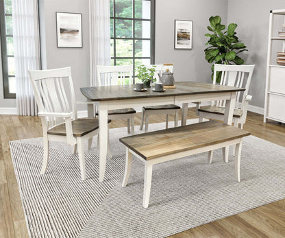 Christy Farmhouse Dining Table set in a modern dining room with matching chairs and bench, featuring Wormy Maple top and White frame.