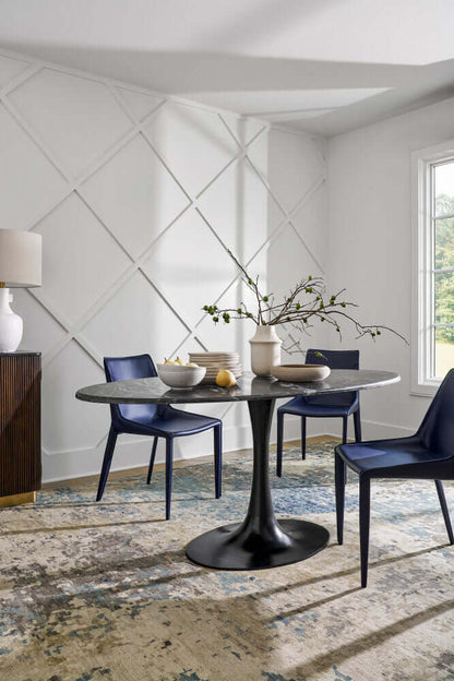 Surya Hanks Navy Dining Chair in a bright dining room setting, paired with a black round table and modern decor.