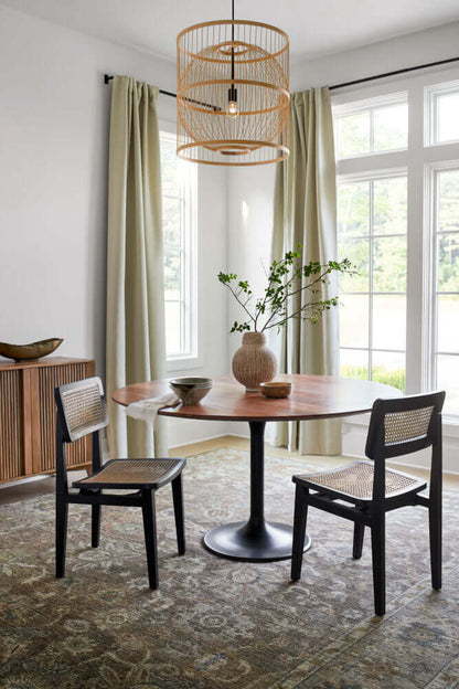 Surya Anatalia Round Brown Dining Table in a modern dining room with natural light and elegant decor.