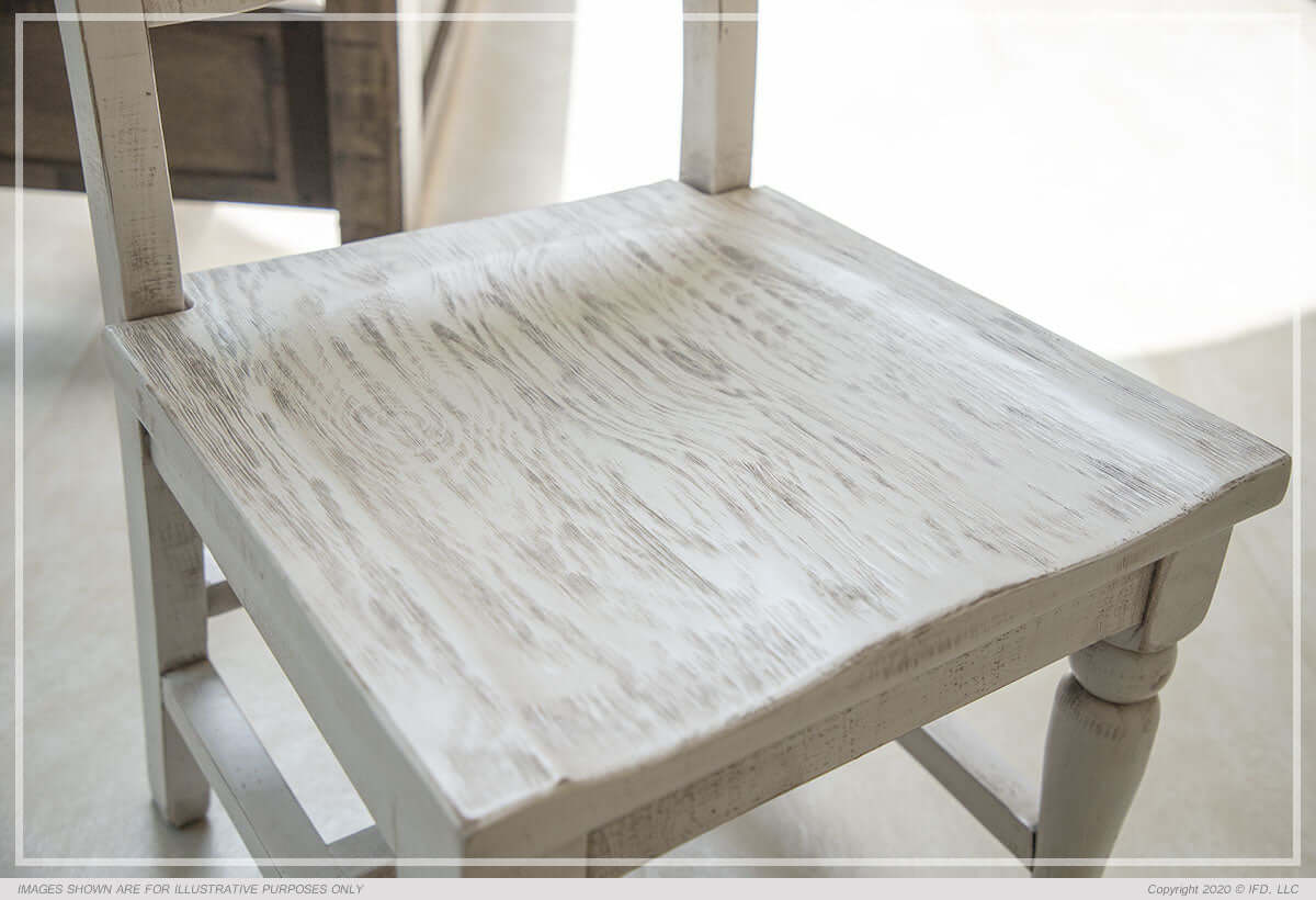 Close-up view of the Rock Valley Dining Chair's solid wood seat with a crisp white finish and rubbed-through details.