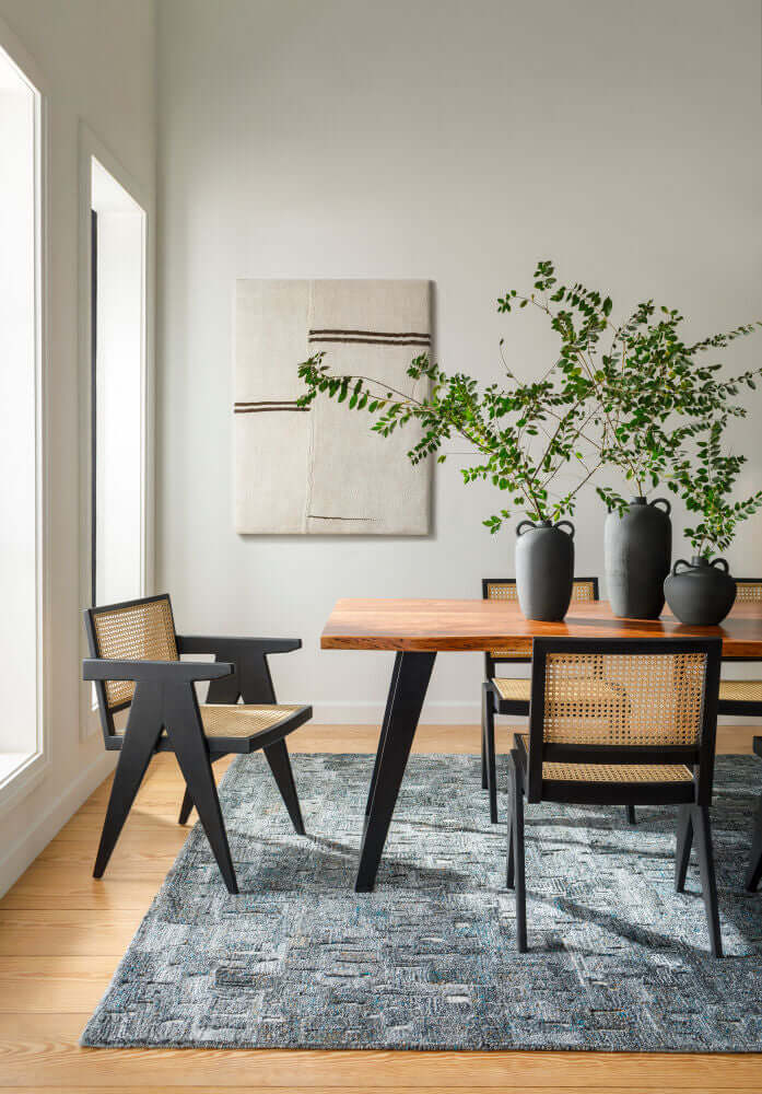 Side view of the Halden dining table showcasing its sleek black iron legs and natural wood grain.