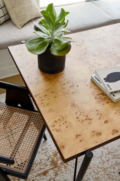 Top view of Judith Dining Table by Surya with natural wood grain and plant centerpiece.