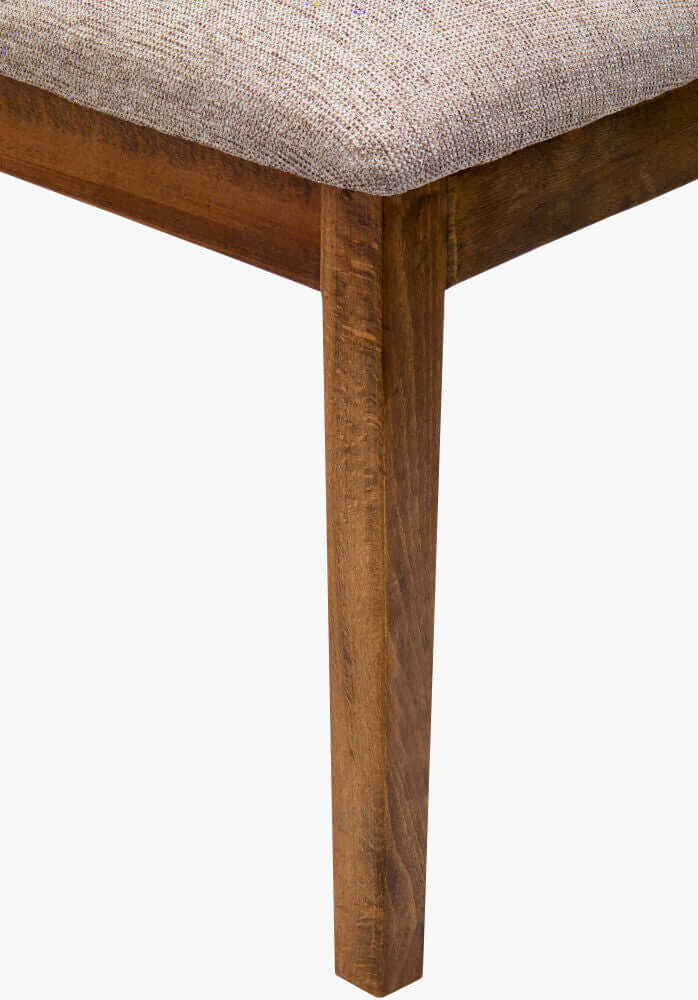 Close-up of the Brooke Dining Chair leg featuring a medium brown beechwood base and textured beige upholstery for a rustic look.