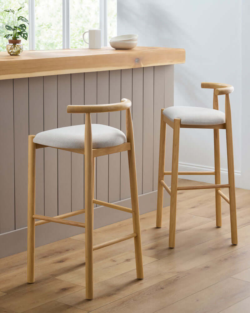 Pair of Callum upholstered bar stools by Surya in a modern kitchen setting.