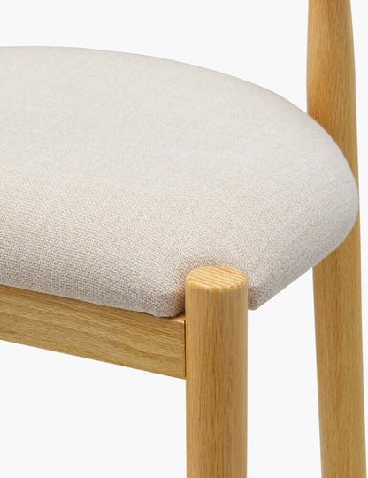 Detailed view of Callum upholstered bar stool's seat with soft polyester fabric.