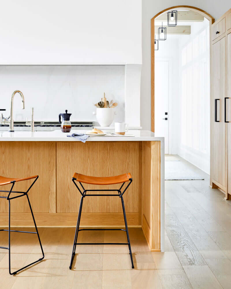 Celerio counter stool by Surya placed at a modern kitchen island, showcasing its minimalist design.