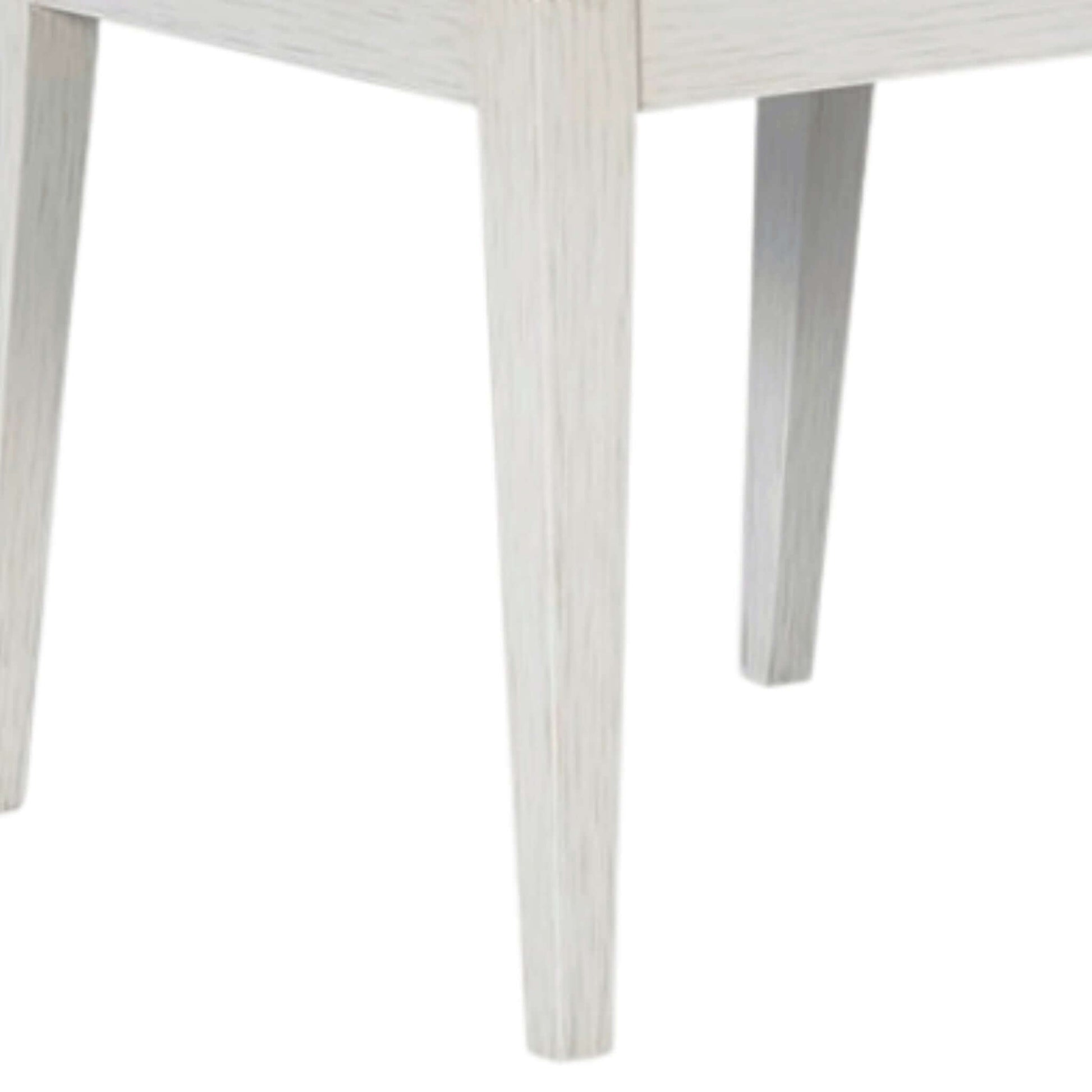 Tapered legs of a grey wood dining chair, showcasing stability and the sophisticated ghost finish for a timeless look.