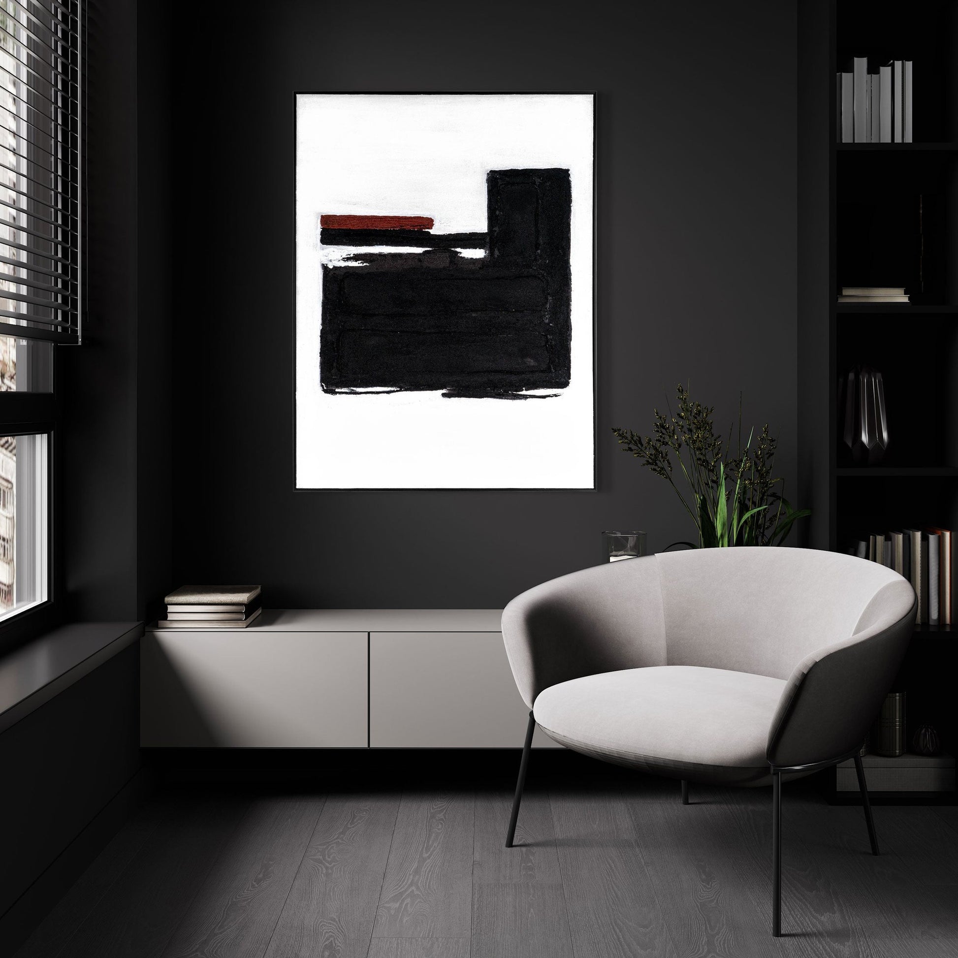 Abstract black and white painting with red accents displayed in a dark modern room with a grey armchair.