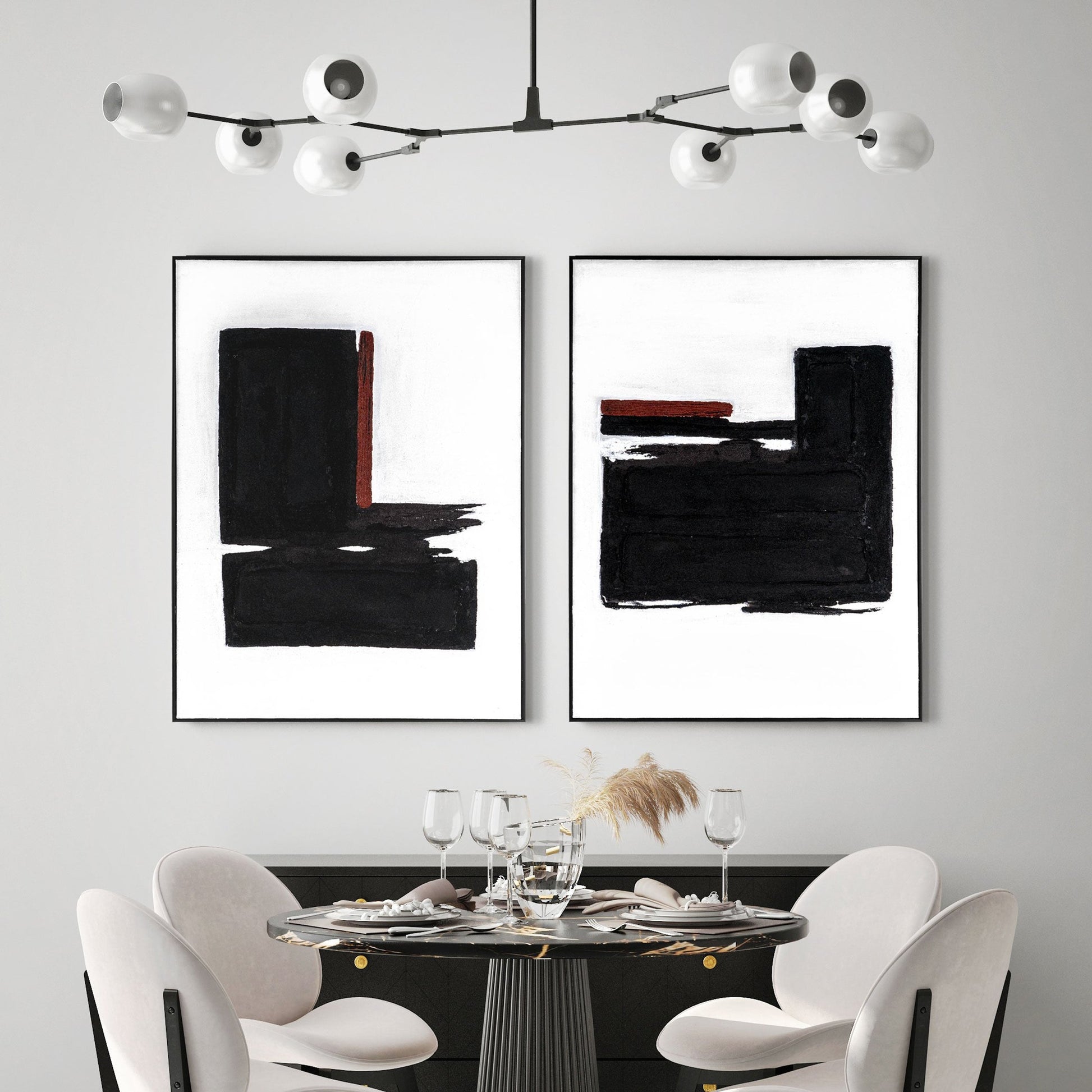 Abstract painting on a white dining room wall with a black and gold dining table.