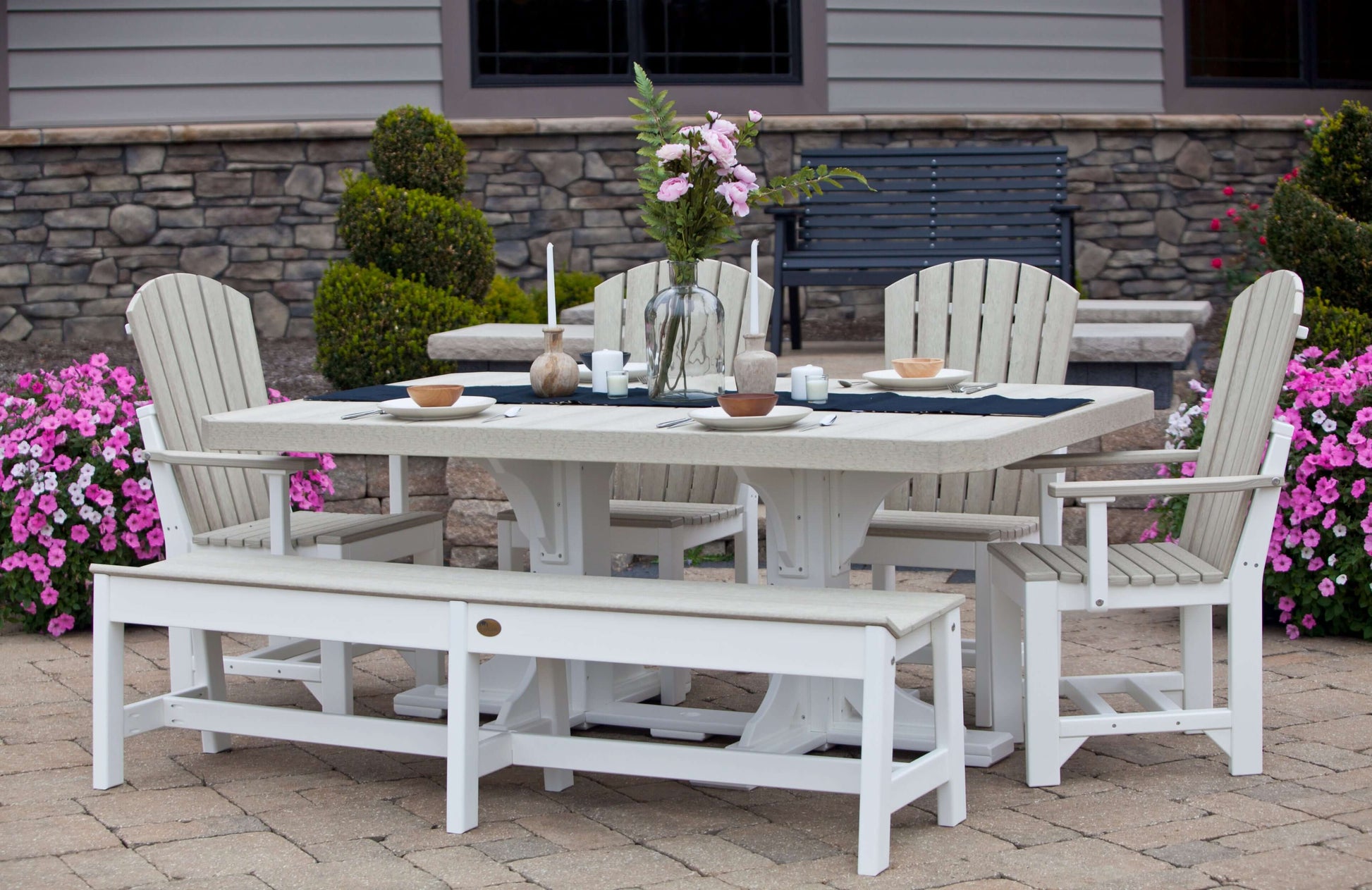 Poly Adirondack Dining Set in a beautifully landscaped garden, capturing the set's practical elegance and inviting atmosphere.