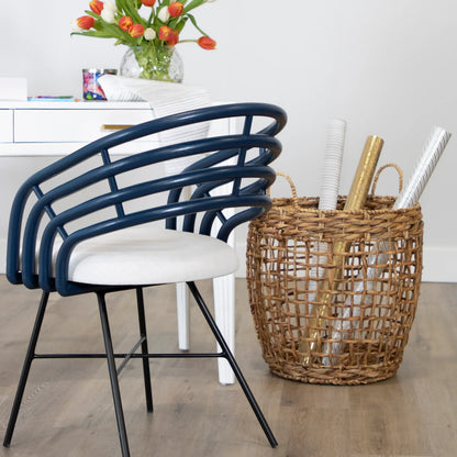 Blue Madrid Dining Chair with white cushion beside a wicker basket in a bright room.