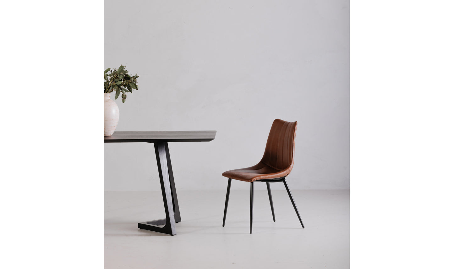 Alibi brown leather dining chair in a modern dining room setting, featuring a contemporary design.