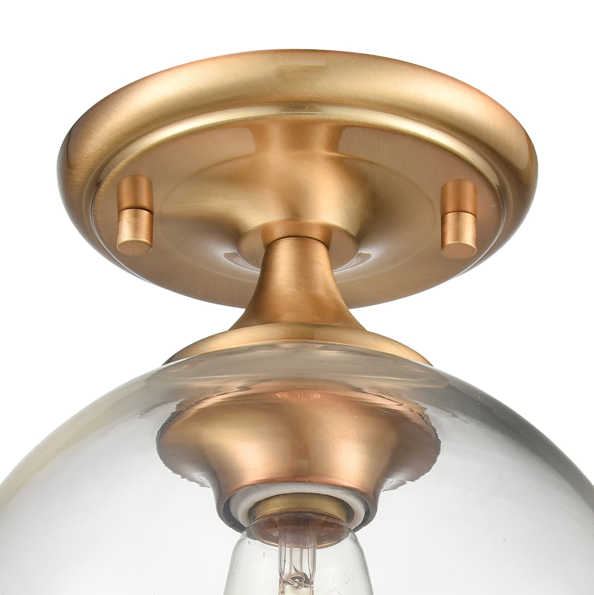 Close-up of brass base with handblown clear globe glass on semi flush mount ceiling fixture.