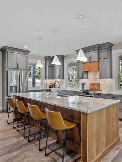 brushed nickel pendant lights illuminating modern gray kitchen.