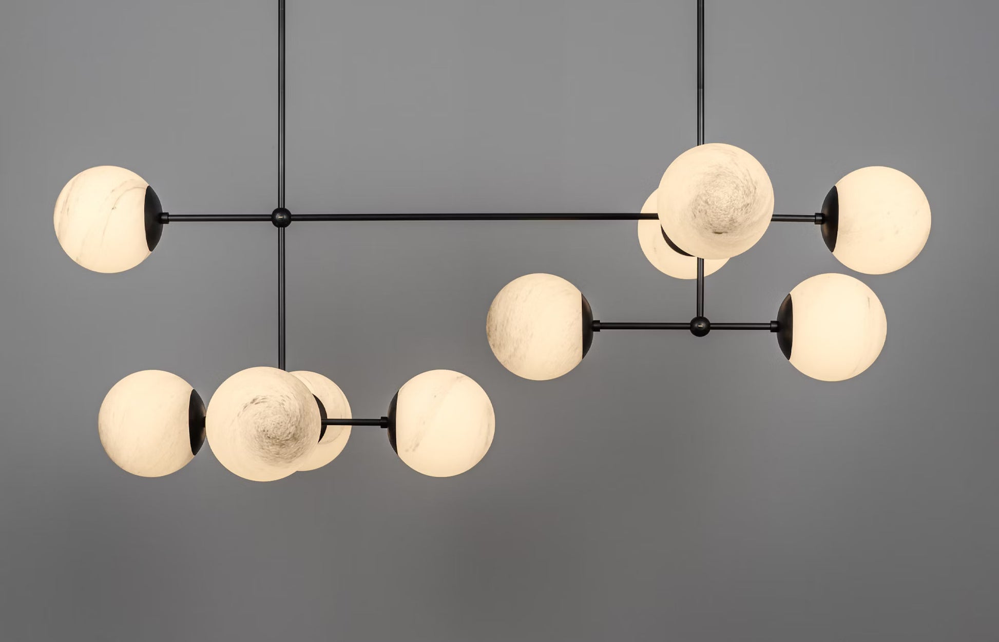 Illuminated Armstrong Linear Chandelier with marble matte glass globes and black gunmetal finish.