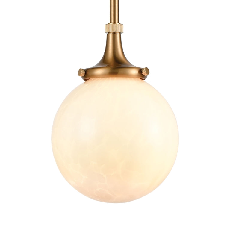 Close-up of white feathered glass shade with satin brass detailing on the pendant light.