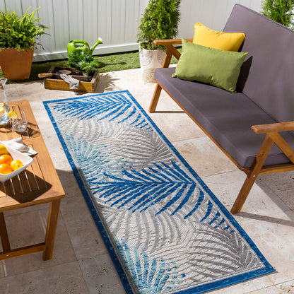 Runner rug with tropical leaf patterns styled on a patio.