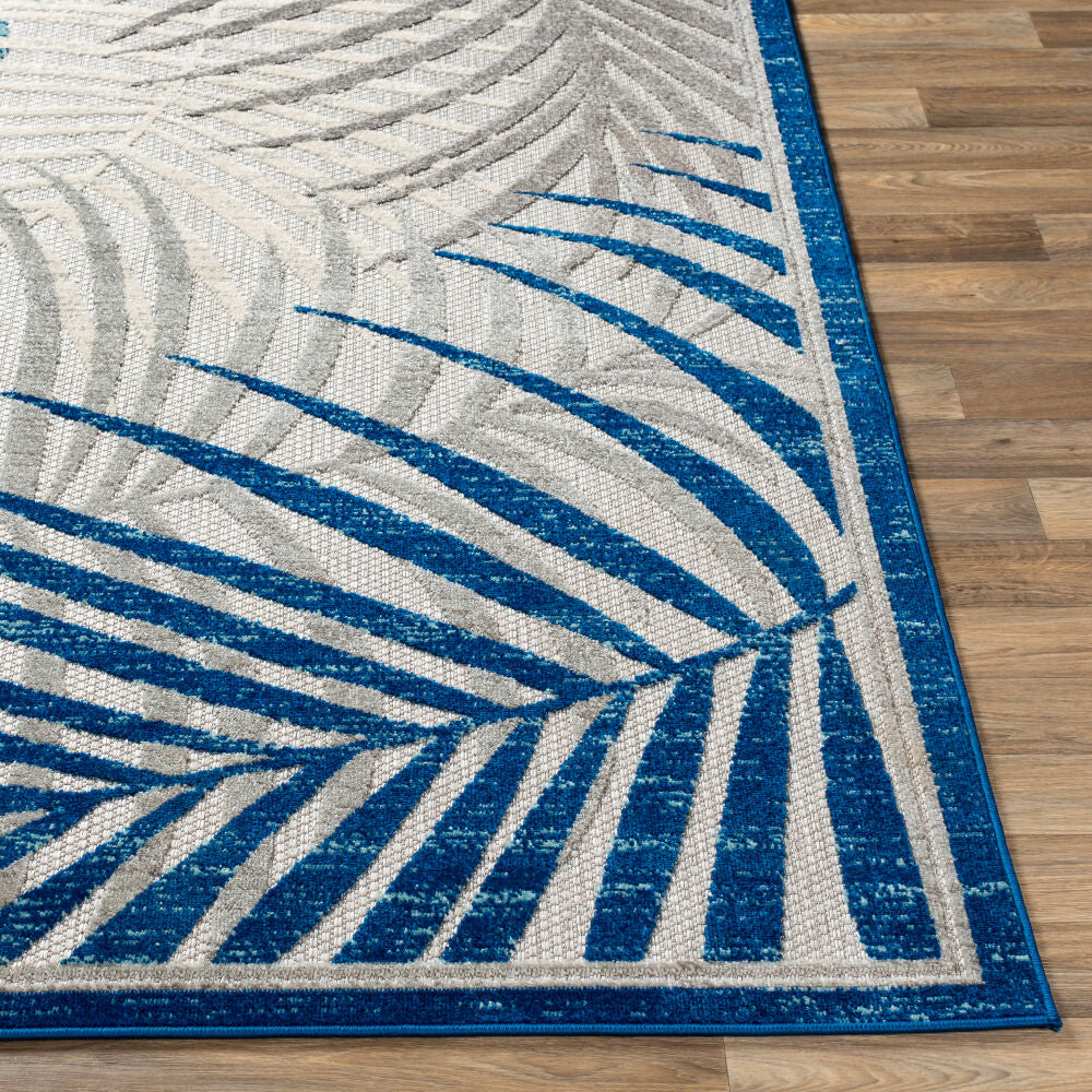 Rug close-up showing intricate palm leaf details and soft texture.