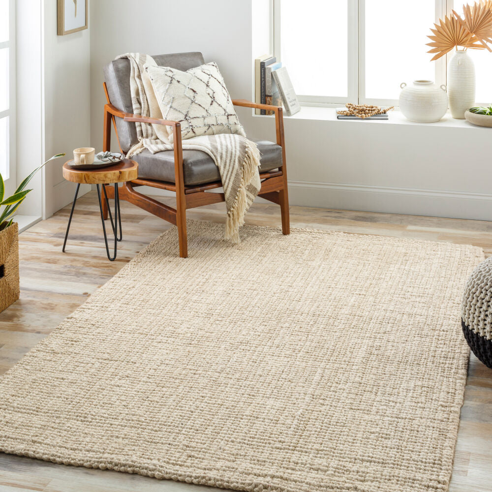 Calla Butter Rug styled in a reading corner with a mid-century modern chair and natural accents.