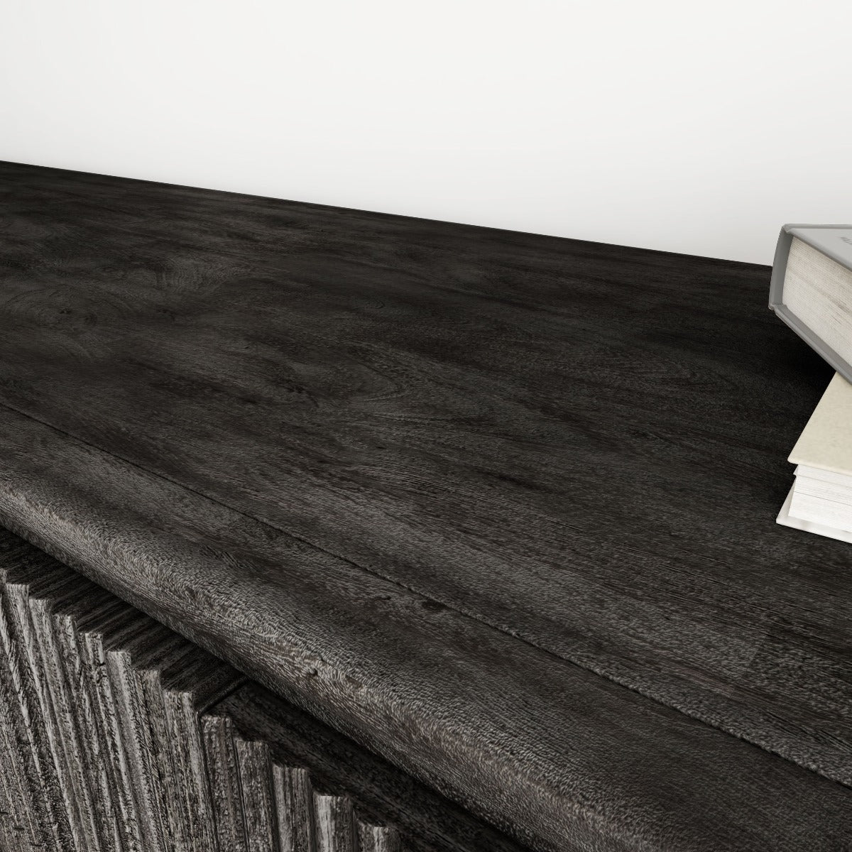 Close-up of the textured black mango wood top surface with books.