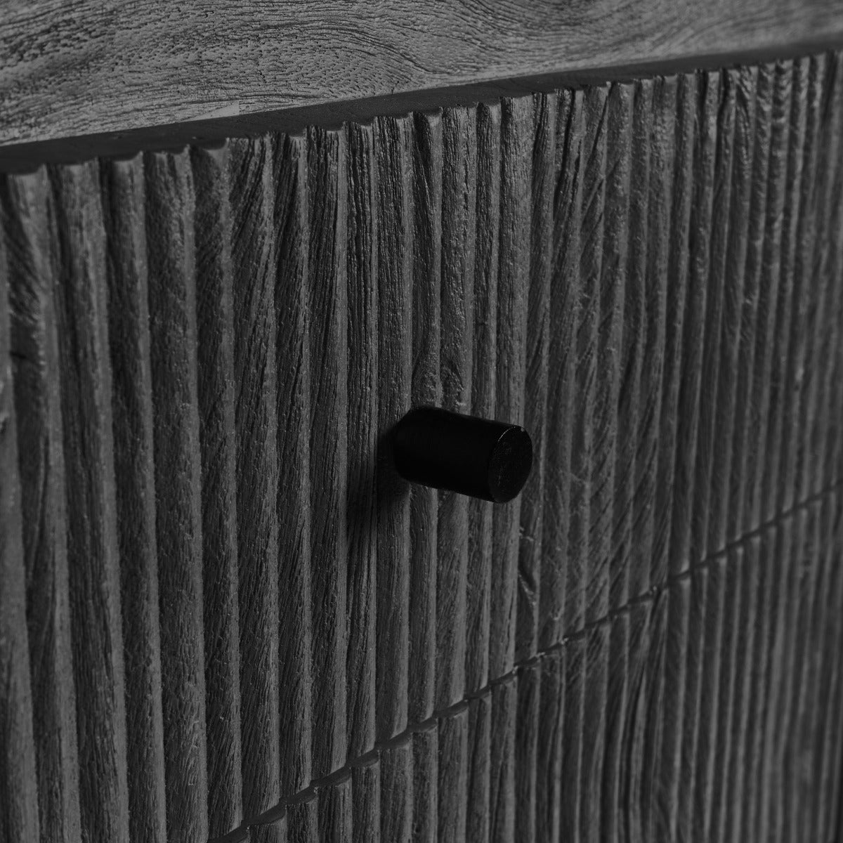 Close-up of textured black door panel with minimal black hardware knob.