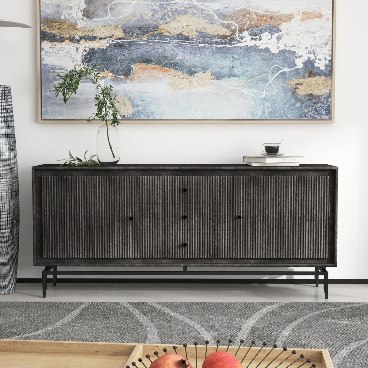 Black sideboard with fluted doors under an abstract painting in a modern living room.