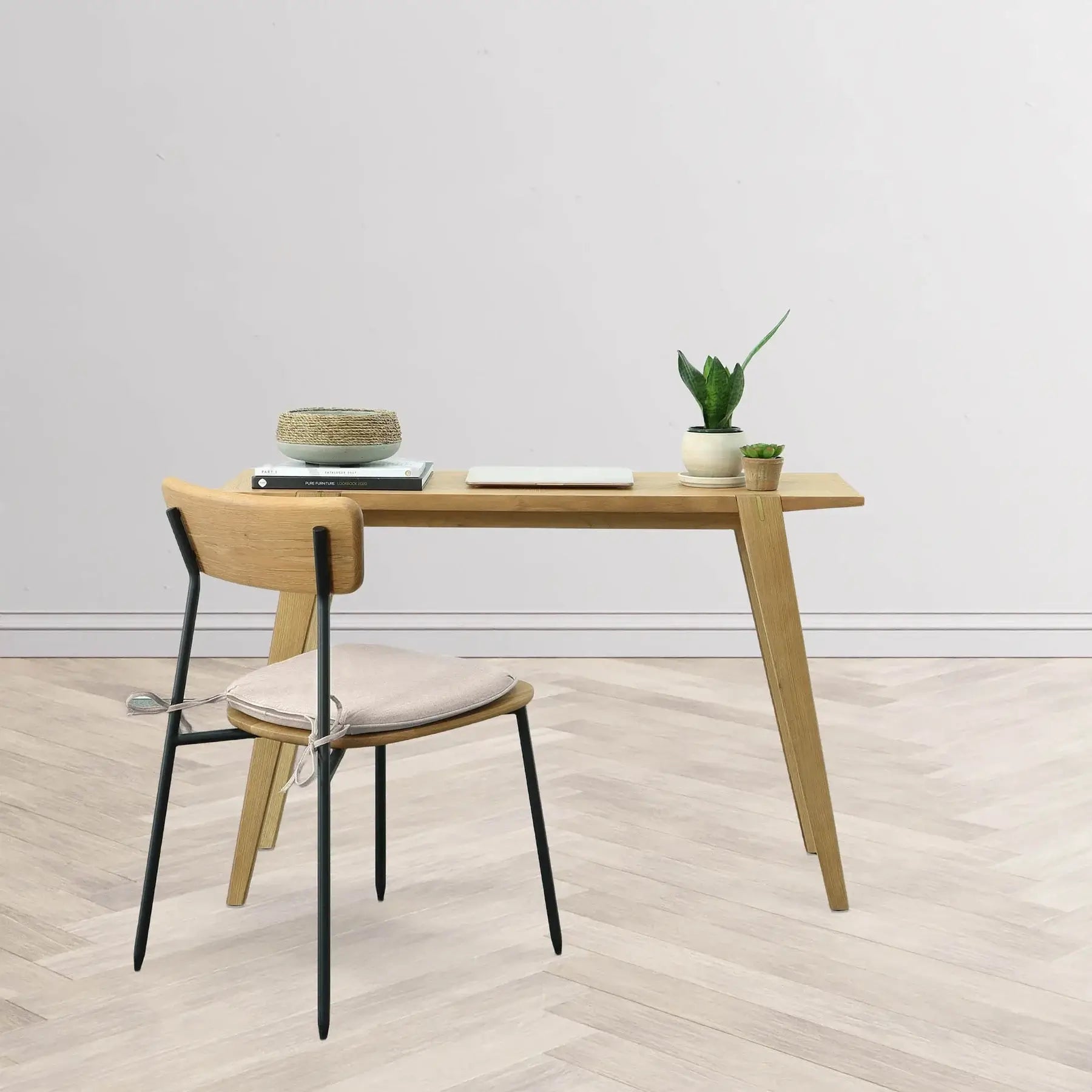 Colton black metal dining chair in a minimalistic home office setup next to a natural wood desk.