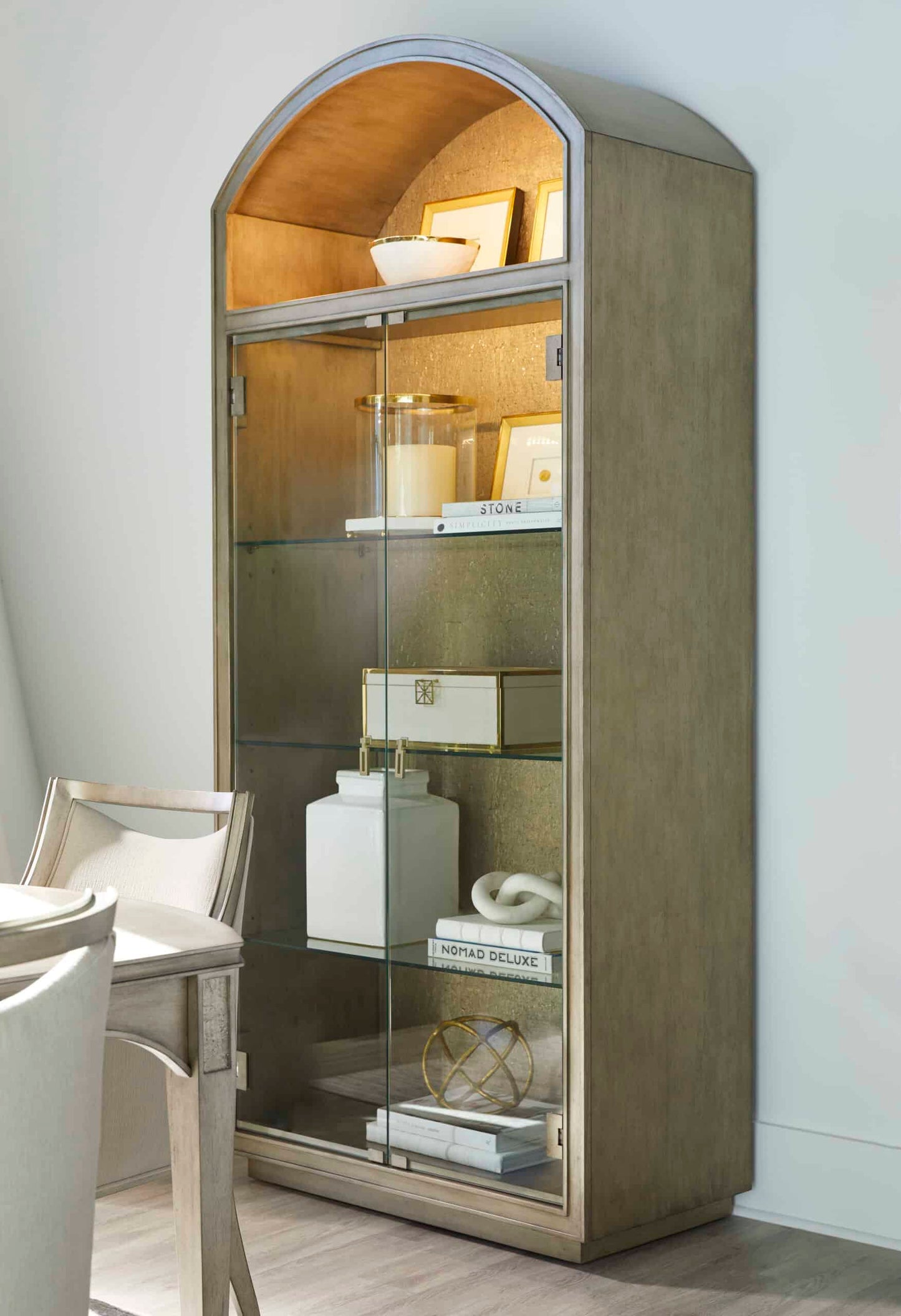  Side view of the Cove Transitional Display Cabinet with glass shelves and decorative items, showcasing its elegant design.