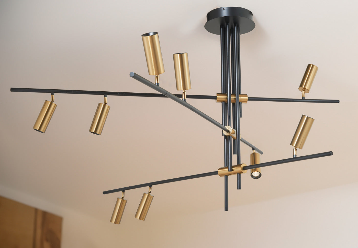 Spartan cylinder pendant light glowing in modern interior ceiling setting.