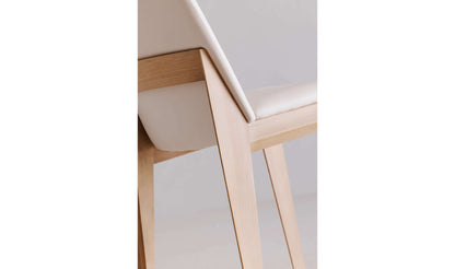 Close-up view of the solid white oak frame and cream vegan leather upholstery of the Deco Cream Dining Chair.