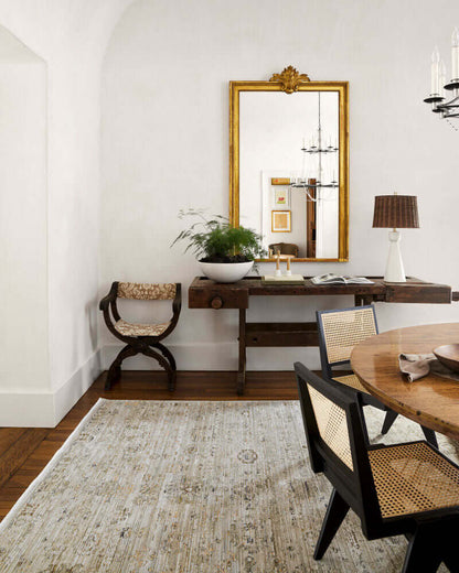 Dining room with rattan dining room chairs and a vintage mirror.