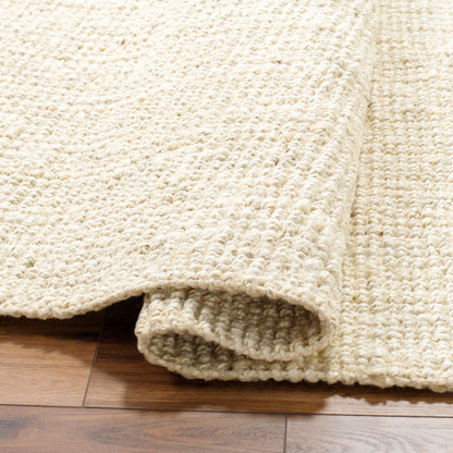 Folded corner of butter jute rug showing handwoven material and clean edges.