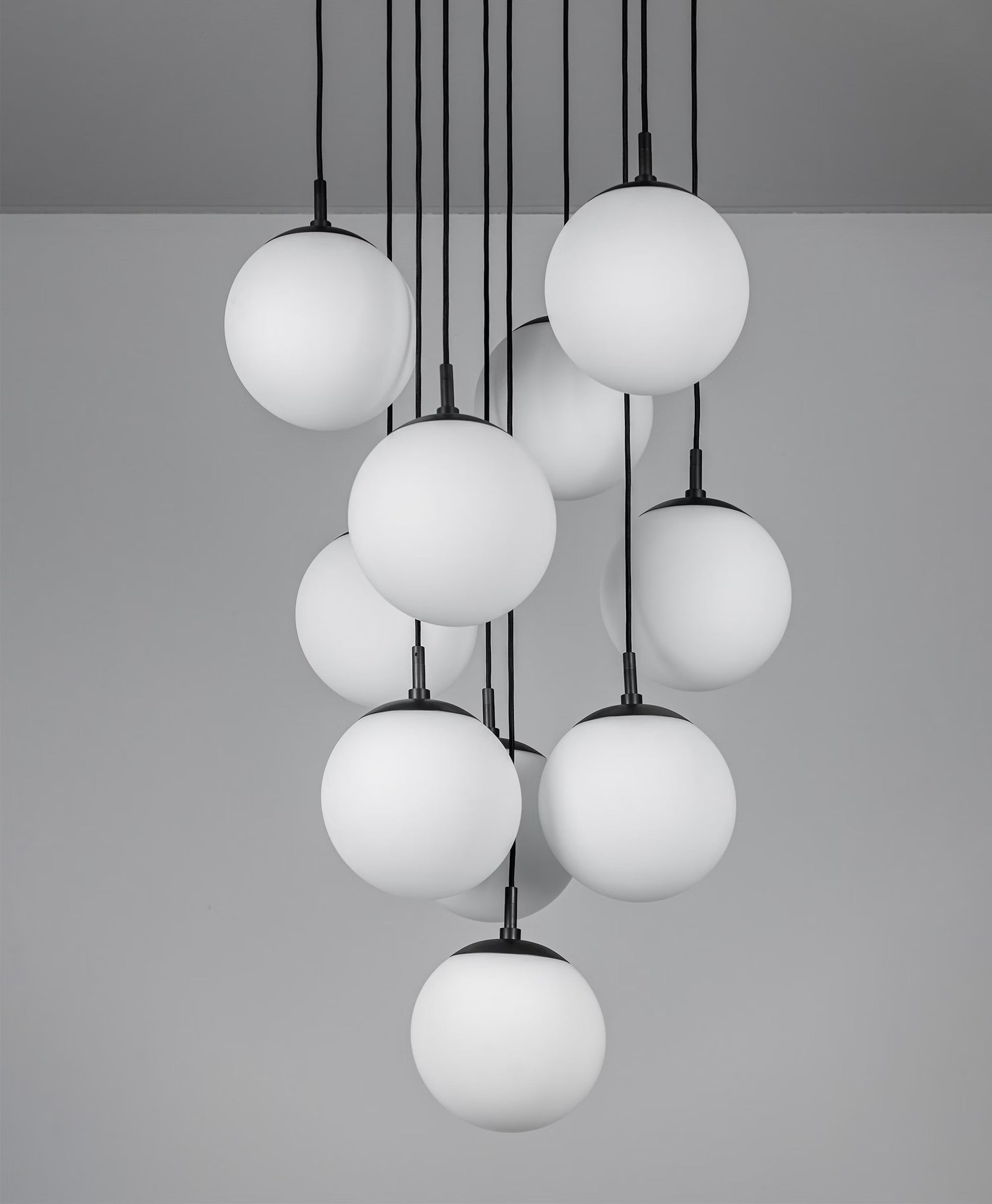 Ten-globe brass chandelier with handblown opal matte glass, suspended elegantly.