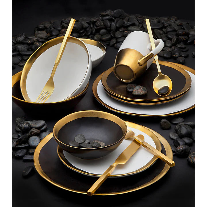 Elegant black and gold dinner set with a luxurious gold rim design, displayed on a black stone .backdrop.