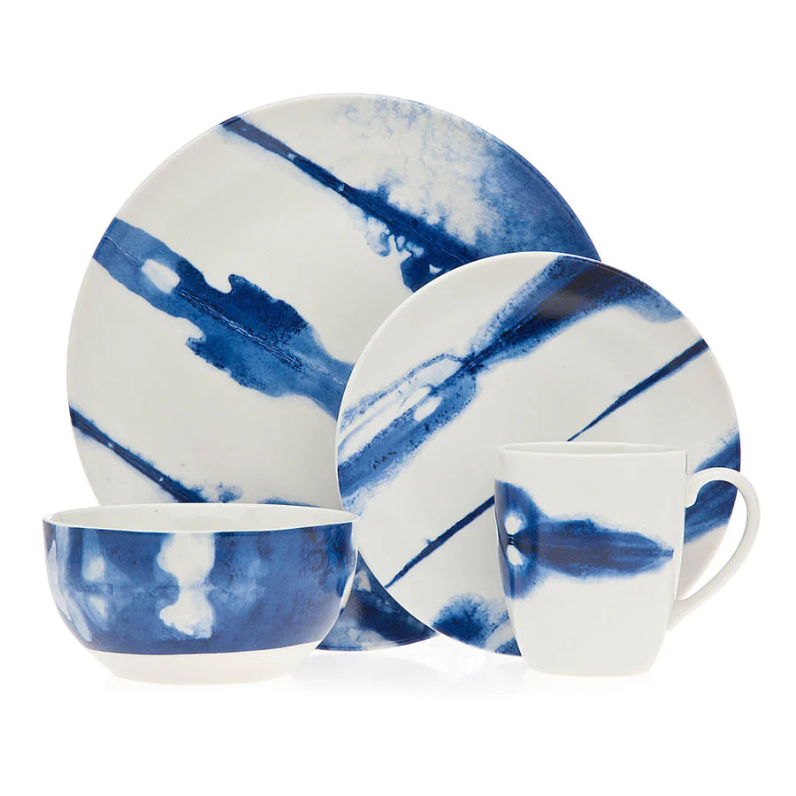 Cielo 16 piece porcelain dinnerware set by Godinger with blue watercolor designs, featuring dinner plates, bowls, and mugs.