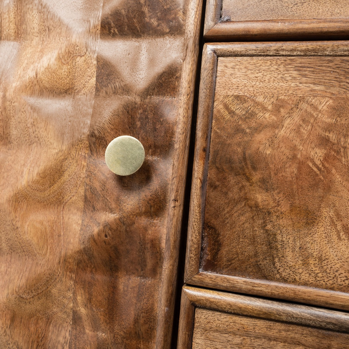 Front-facing close-up of drawers with gold handles and natural wood texture.