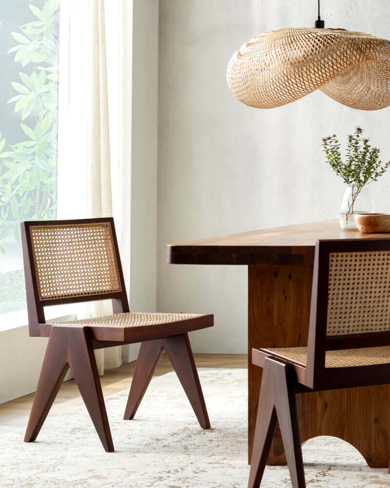  A beautifully styled dining room showcasing the Hague Dining Chair by Surya with rattan seat and backrest.