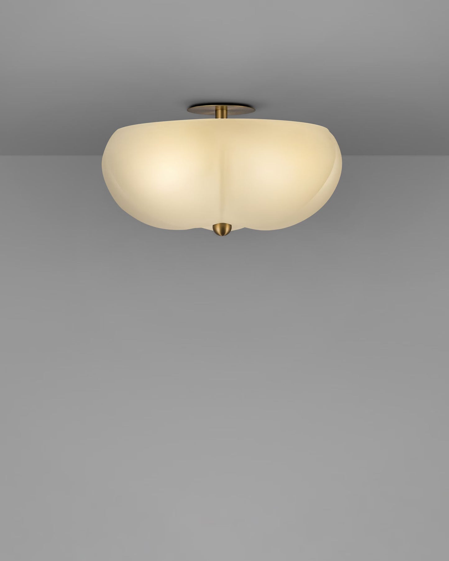 Hana Flush Mount illuminated with warm light, showcasing its soft, rounded glass shade.