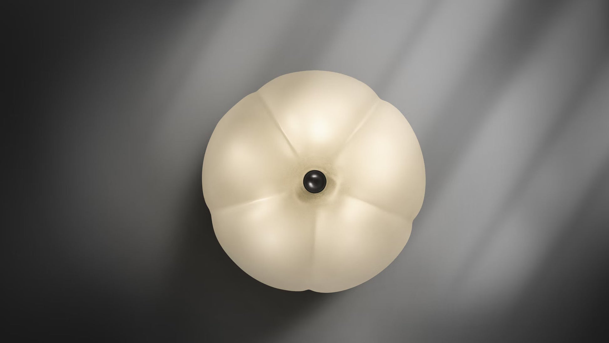 Top-down view of frosted glass Hana Flush Mount with brass button centerpiece.