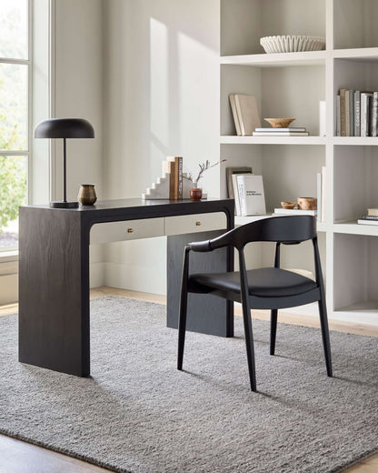 Kisco Dining Arm Chair by Surya placed next to a sleek black desk in a bright room