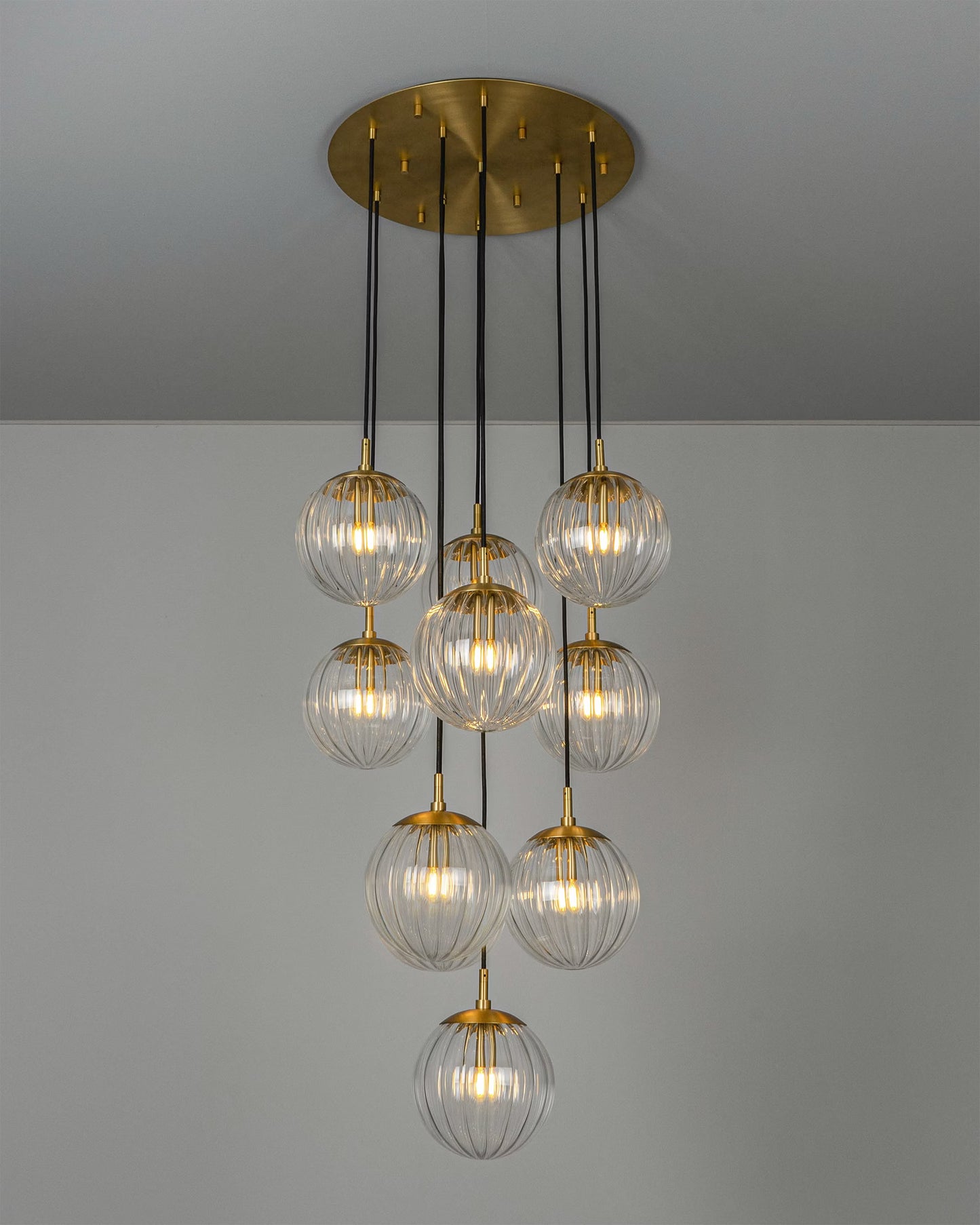 Illuminated chandelier with clear glass globes and brass accents, exuding warmth and luxury.