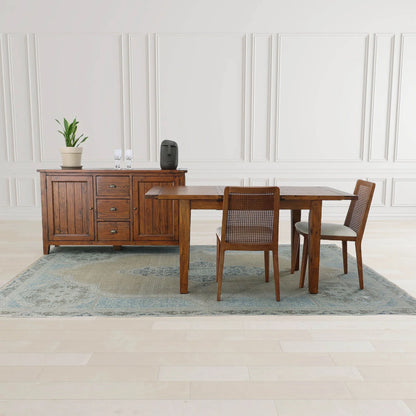 Irish Coast Large Brown Wood Sideboard in African Dusk finish displayed with table and chairs in modern setting.