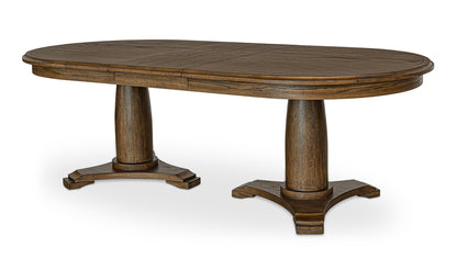 Full view of the Jamie brown extension dining table in its oval shape, extended and displaying its sturdy double pedestal base.