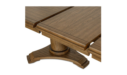 Close-up of the wooden dining table with an extendable leaf mechanism and pedestal base, highlighting the rich wood grain and craftsmanship.