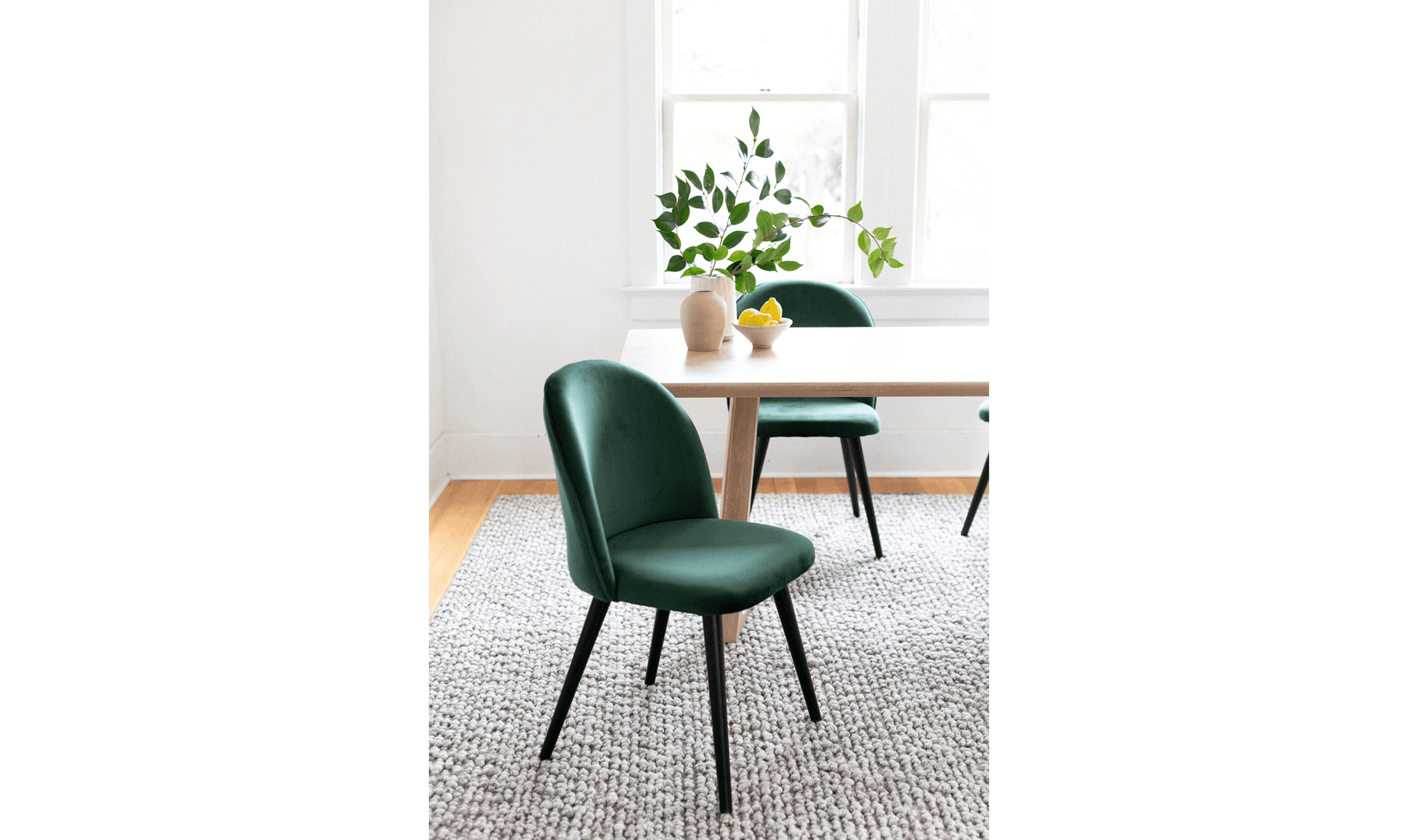 Pair of Clarissa Green Dining Chairs in a dining room setting with a stylish table.