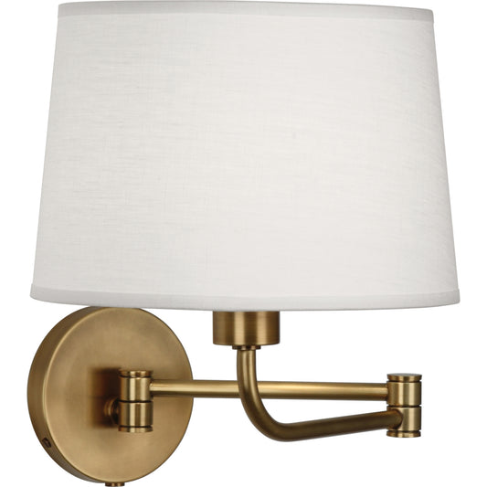 Koleman wall swinger in aged brass with oyster linen shade and adjustable swing arm.