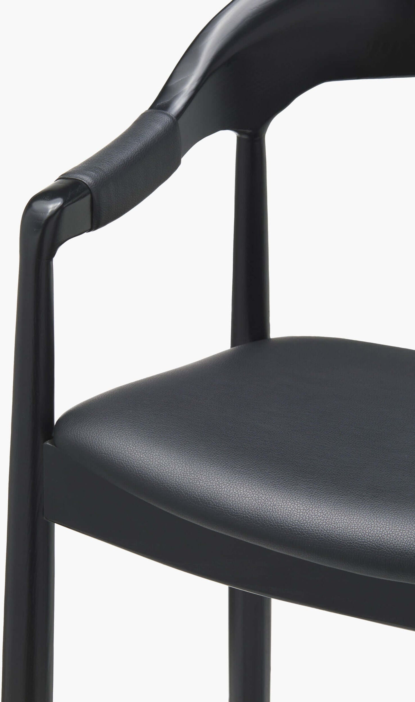 Close-up view of the Kisco Bar Stool seat edge, featuring black faux leather upholstery and smooth finish.