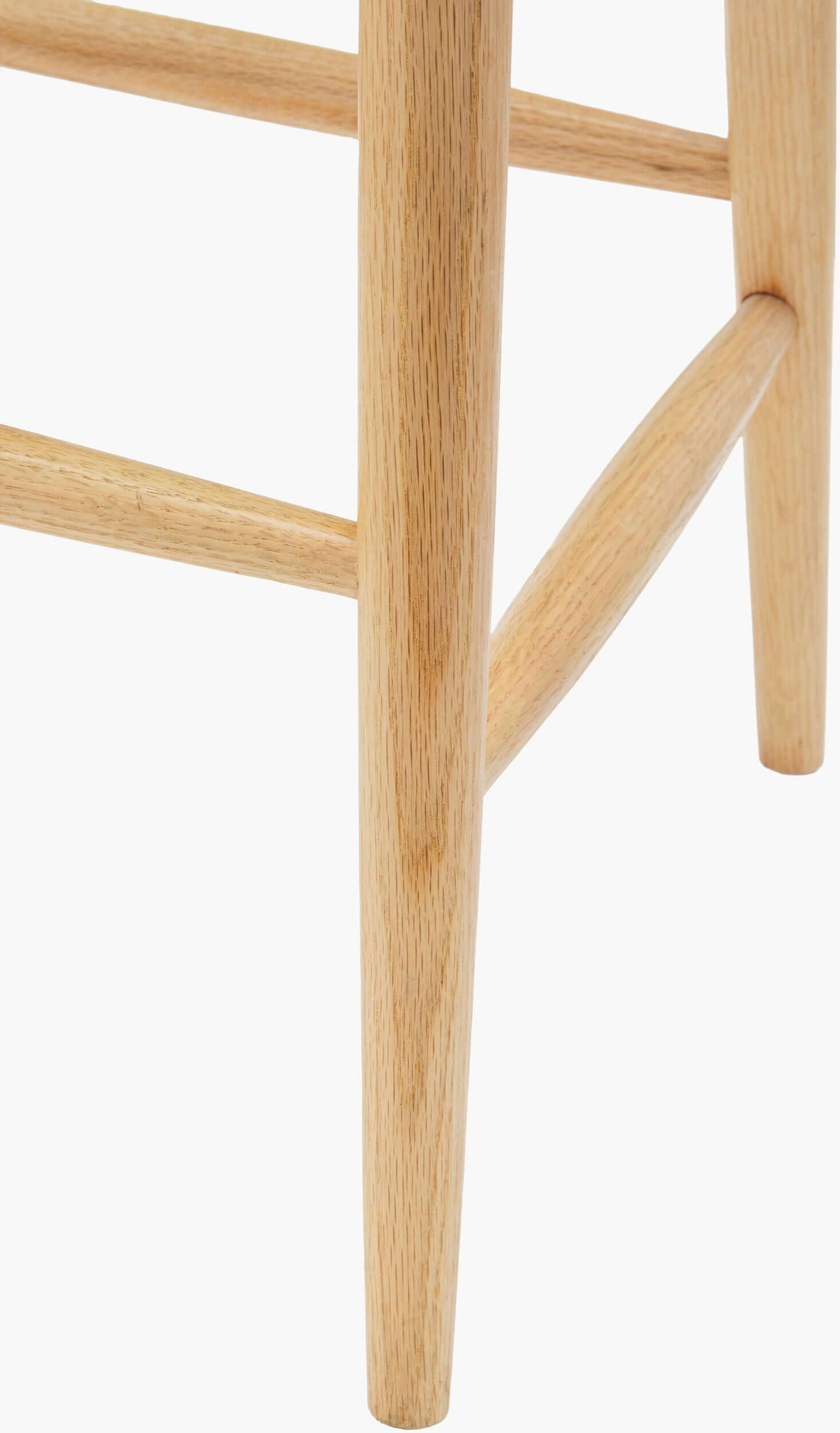 Close-up view of the leg of the Kisco Natural Bar Stool by Surya, displaying the robust natural wooden construction.